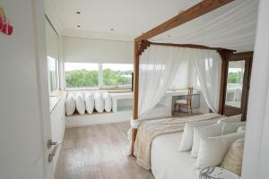 een slaapkamer met een hemelbed en een raam bij Los Muelles Boutique Hotel in Carmelo