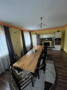 une salle à manger avec une table et des chaises en bois dans l'établissement Cabana Bianca & Iair, à Poiana Vadului
