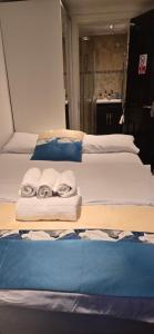 two beds with towels sitting on top of them at Exclusive Private One Bedroom Suite in London