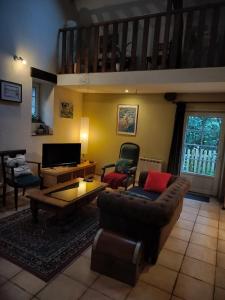 un salon avec un canapé et une table dans l'établissement Le p'tit hameau de Sey, à Quettehou