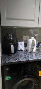 a counter top with appliances on top of a microwave at Exclusive Private One Bedroom Suite in London