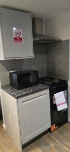 a microwave sitting on top of a counter in a kitchen at Exclusive Private One Bedroom Suite in London