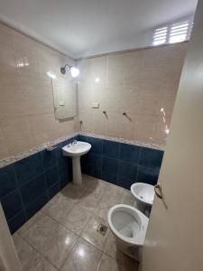 a bathroom with two toilets and a sink and a mirror at La casa del varón in Mina Clavero +12 photos
