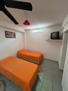 a room with two beds and a tv at La casa del varón in Mina Clavero