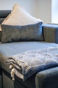 een deken zittend op een bank met twee kussens bij Sedgebank House in Uphall