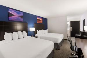 a hotel room with two beds and a television at SureStay by Best Western Presque Isle in Presque Isle
