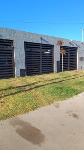 un edificio con due porte da garage e un piccolo albero di Once Reinas Departamentos a San Rafael