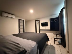 a bedroom with a bed and a tv on the wall at Hotel Ossi Inn in Matamoros