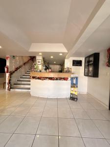 马塔莫罗斯Hotel Ossi Inn的商店的大堂,有柜台和楼梯