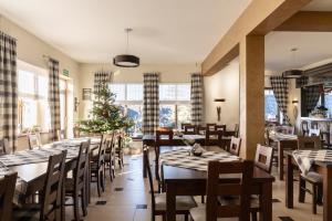 a restaurant with tables and chairs and a christmas tree at Willa Tatrzańska Luxury Apartments & Spa in Murzasichle