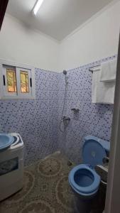 bagno con servizi igienici blu e lavandino di Bienvenue chez vous a Libreville
