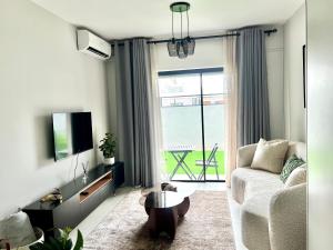 a living room with a couch and a tv at Cozy Habitat in Gaborone
