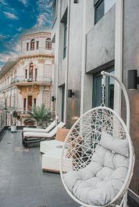 einen Schaukelstuhl auf einem Balkon mit einem Gebäude in der Unterkunft Hotel de Turistas Iquitos in Iquitos