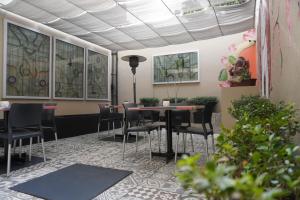 een kamer met tafels en stoelen en glas-in-loodramen bij Árbol Suites in Tijuana