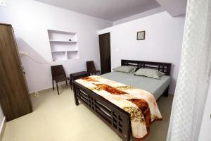 a bedroom with a bed and a chair in it at Dream Garden Homestay in Madikeri +18 photos