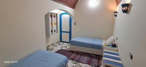 阿斯旺malindy KA nubian houseماليندى كا的小房间设有蓝色的床和门 更多155张照片