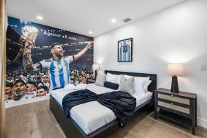a bedroom with a bed and a poster of a soccer game at Luxury Home with Inter Miami Theme in Miami