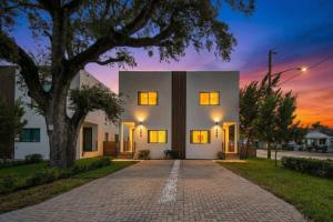 a large white house with a tree on a driveway at Luxury Home with Inter Miami Theme in Miami +62 photos