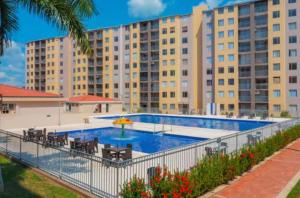 een zwembad met stoelen en een groot gebouw bij Loft Vacaciional in Ricaurte +7 foto's