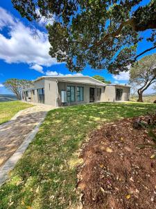 a house on a grassy field with a tree at Forestview Luxury Farm Stay in Bellcrest