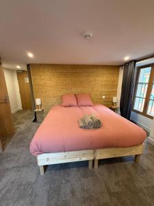 a bedroom with a large bed with pink sheets at Le Touring in Isola