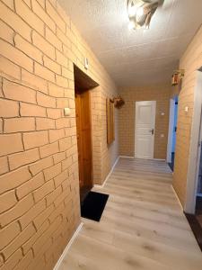an empty room with a brick wall and a wooden floor at Parko apartamentai Kretinga in Kretinga
