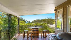 une terrasse avec une table et des chaises sur un balcon dans l'établissement Mountain Breeze, à Umina