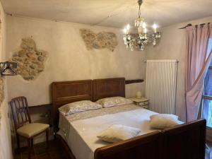 a bedroom with a large bed and a chandelier at La Casa di Paolo in Battifollo