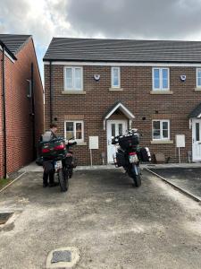 twee motorfietsen geparkeerd voor een bakstenen huis bij Jakes Beach house in Hartlepool