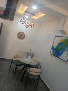 a table and chairs in a room with a painting at Luxury 3 Bedroom Duplex with Mini Swimming Pool in Enugu