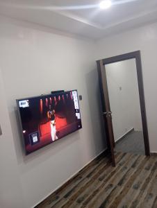 a flat screen tv hanging on a wall at Luxury 3 Bedroom Duplex with Mini Swimming Pool in Enugu