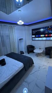 una camera con un grande letto e un grande schermo di Le Cocoon a Nevers