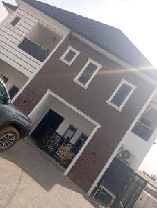 a house with a car parked in front of it at Luxury 3 Bedroom Duplex with Mini Swimming Pool in Enugu