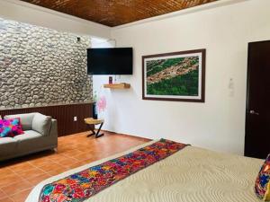 a living room with a bed and a couch at Los Suspiros Hotel Boutique & Spa in Comala