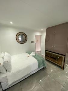 - une chambre avec un lit blanc et une cheminée dans l'établissement Exclusive Townhouse at The Square, à Port Elizabeth