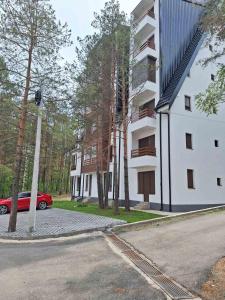 een rode auto geparkeerd voor een gebouw bij Pino Silvestre Divčibare in Divčibare +13 foto's