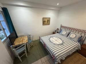 una camera da letto con un letto, un tavolo e una finestra di Auberge de la Croix du Pape a Èze