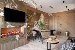 uma sala de estar com lareira e uma televisão na parede em Willa Tatrzańska Luxury Apartments & Spa em Murzasichle