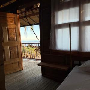 una camera da letto con vista sull'oceano da un balcone di Altos de la Playa a Bahía Solano
