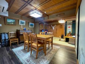 une salle à manger avec une table et des chaises en bois dans l'établissement Kokoro no Yado, à Nara