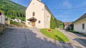 een klein wit kerkje met een rode bloem in het gras bij Apartment Gletscher & Fluß in Penk