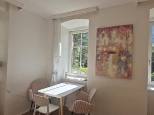 een eetkamer met een tafel en stoelen en een schilderij bij Apartment Gletscher & Fluß in Penk