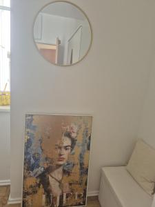 een spiegel aan de muur met een schilderij van een vrouw bij Apartment Gletscher & Fluß in Penk