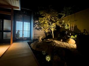 une pièce avec un jardin et une personne debout à une fenêtre dans l'établissement Kokoro no Yado, à Nara 18 autres photos