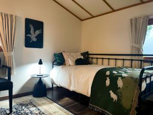 une chambre avec un lit avec une couette verte dans l'établissement Kokoro no Yado, à Nara