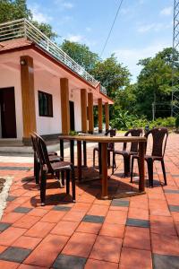 a wooden table and chairs on a patio at Dream Garden Homestay in Madikeri