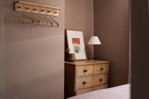 een slaapkamer met een dressoir waarop een schilderij en een lamp staan bij Traditional Cornish Cottage & Garden Redruth in Redruth +38 foto's