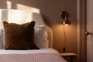 een slaapkamer met een bed met een kussen en een lamp bij Traditional Cornish Cottage & Garden Redruth in Redruth