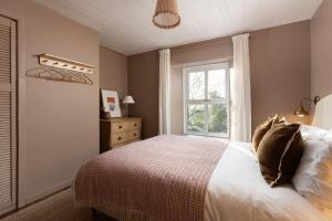 een slaapkamer met een bed en een raam bij Traditional Cornish Cottage & Garden Redruth in Redruth