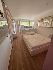 ein Schlafzimmer mit einem großen Bett und Holzböden in der Unterkunft Charmant Studio in La Motte-dʼAigues